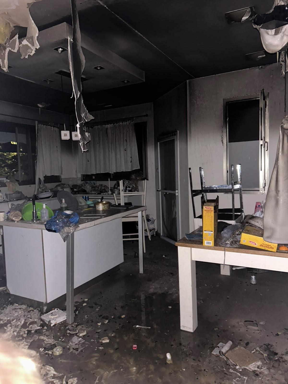 ביתם השרוף של משפחת קליינמן — תקרה מפוחמת ורצפה מכוסה פיח ומים